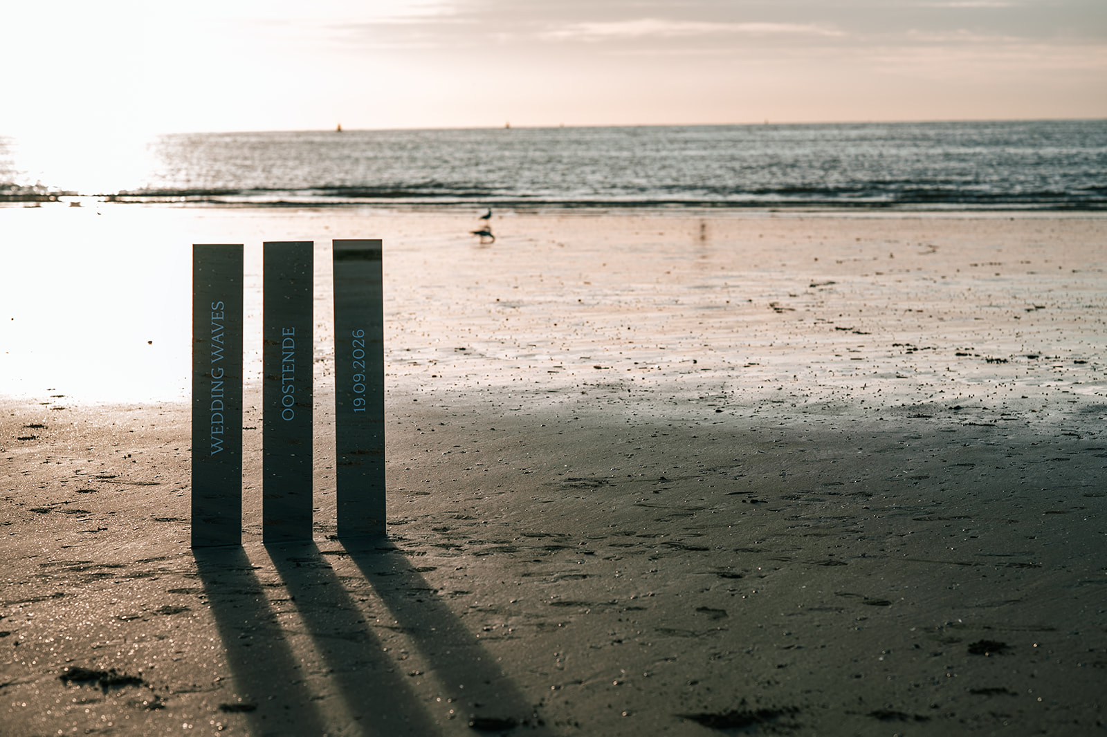 Drie verticale spiegelpalen van Wedding Waves op het strand van Oostende